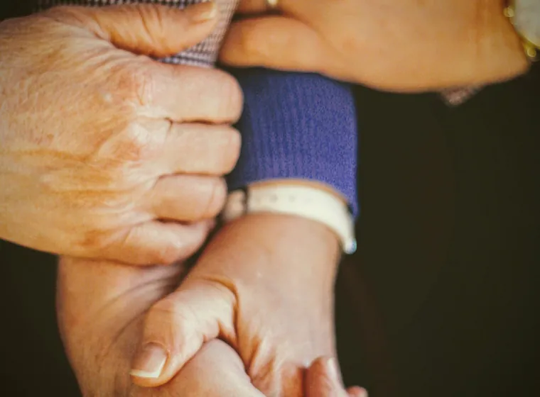 Two people holding hands across a table