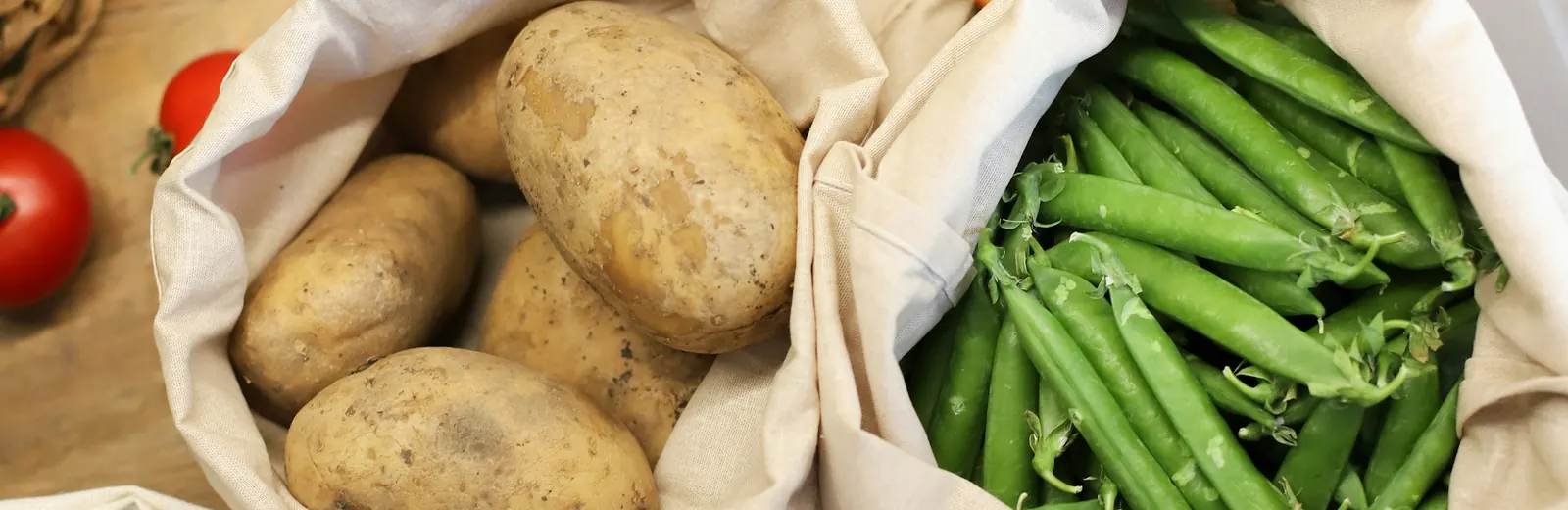Fresh groceries being packed into a paper bag at a kitchen counter