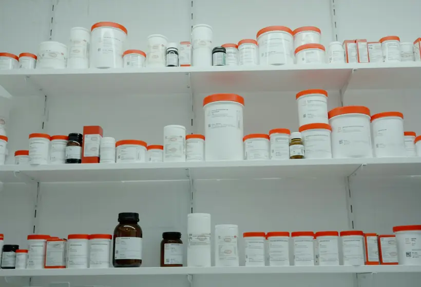 Prescription bottles lined up on a pharmacy counter